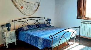1 dormitorio con 1 cama y 1 hamaca colgada en la pared en Casa Adua, en Donoratico