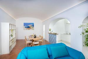 a living room with a blue couch and a table at Casa Luma, il sogno di Positano! in Positano