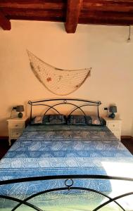a bedroom with a bed with a metal head board at Casa Adua in Donoratico