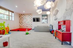 a child sitting in a room with a climbing wall at Whiteblue apartamenty Kołobrzeg in Kołobrzeg +32 photos
