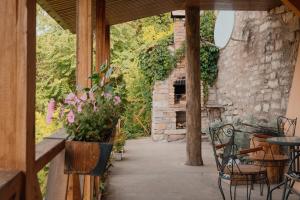 un patio con chimenea de piedra, mesa y sillas en Дом с видом на старую крепость, en Kamianets-Podilskyi