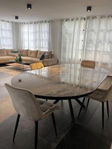 sala de estar con mesa de cristal y sillas en A cozy place with free parking and spacious garden, 
