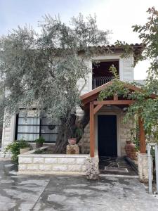 une maison avec un arbre en face dans l'établissement A cozy place with free parking and spacious garden, 