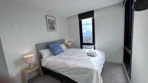 une chambre avec un lit et une grande fenêtre dans l'établissement Nest Apartments MEET Empire, à Melbourne 91 autres photos
