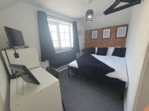 a bedroom with a bed and a desk with a television at Little House On The Hill Conisbrough in Conisbrough