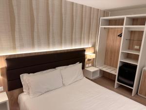 リド・ディ・イエゾロにあるHotel Derby Sのベッドルーム(白いベッド、黒いヘッドボード付)