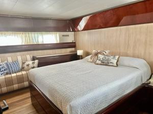 una camera da letto su una barca con un letto e un divano di MotorYacht 21 avec équipage a Barcellona
