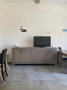 ein Wohnzimmer mit einem Flachbild-TV auf einem Schrank in der Unterkunft Le Cysphée chez Christelle in Sallertaine