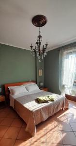 a bedroom with a bed and a chandelier at Casa Vacanze Le tre Sorelle in Torre Pellice