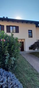 a house with a brick driveway and flowers in front of it at Casa Vacanze Le tre Sorelle in Torre Pellice