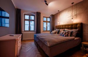 ein Schlafzimmer mit einem großen Bett und zwei Fenstern in der Unterkunft MARKT LIFE HOME APPARTMENTS in Lutherstadt Wittenberg