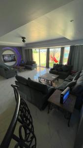 una sala de estar con sofás, mesas y un arco iris en فيلا بمسبح خاص درة العروس, en Durat Alarous