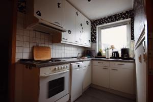 a kitchen with white cabinets and a stove and a window at Ferienwohnung 1 Höller in Grömitz
