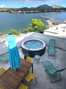 patio con tavolo e sedie e vasca idromassaggio. di Apartments Picikato a Bilice (Bilizze)