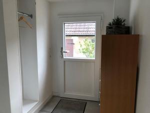 a white door with a window in a room at Allis Kajüte - Entspannen im großen Garten oder vorm Kamin in Lübeck