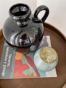 um bule de chá de metal sentado em cima de uma revista em Estilosa casa golf em Gorraiz