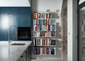 a kitchen with a book shelf filled with books at Bouquerie Lagrasse in Lagrasse