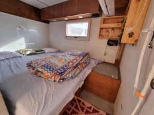1 dormitorio pequeño con 1 cama en un remolque en ג'וני- חוויה בקארוון מדברי, en Sappir