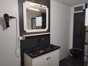 een badkamer met een zwarte wastafel en een spiegel bij PUSULA MOTEL in Akçatepe