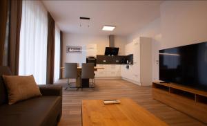 a living room with a couch and a television and a table at Deluxe Apartment Leibnitz in Leibnitz