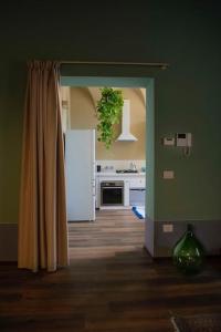 uma cozinha com paredes verdes e um frigorífico branco em Casa Asja: Cromatismo in centro storico em Cesena