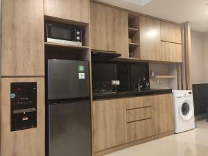 Irvine Suites Lantai 26-I2618 في سيكارانغ: مطبخ مع ثلاجة سوداء وميكرويف