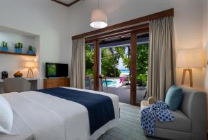 Schlafzimmer mit einem Bett und einer Glasschiebetür in der Unterkunft Ifuru Island Resort Maldives - 24-Hours Premium All-inclusive with Free Domestic Transfer in Raa Atoll