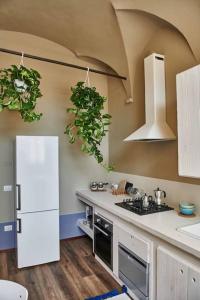 a kitchen with a white refrigerator and a stove at Casa Asja: Cromatismo in centro storico in Cesena