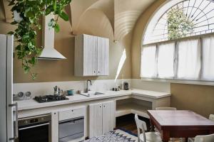 uma cozinha com uma mesa e uma grande janela em Casa Asja: Cromatismo in centro storico em Cesena