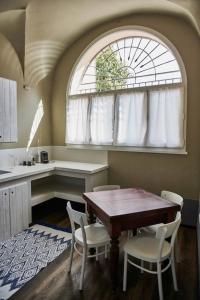uma cozinha com mesa e cadeiras e uma janela em Casa Asja: Cromatismo in centro storico em Cesena