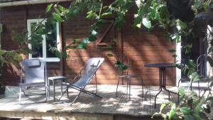 3 chaises et une table sur une terrasse dans l'établissement le gite du hérisson, 