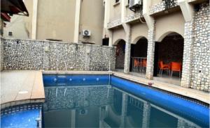 a swimming pool in front of a building at Room in Lodge - Choice Gate Hotel-Business Double in Benin City