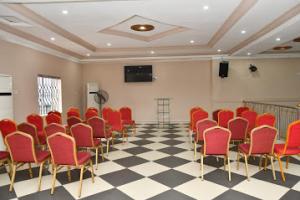 Zimmer mit roten Stühlen und kariertem Boden in der Unterkunft Room in Lodge - Choice Gate Hotel-Business Double in Benin-Stadt