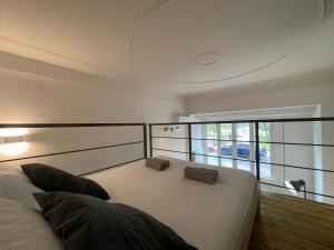 Un dormitorio con una gran cama blanca y una ventana en Navigli Design Loft - 7 stops from Duomo, AC, Netflix, en Milán