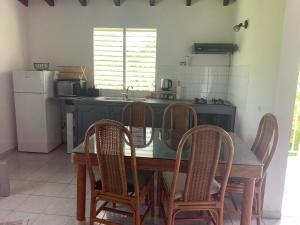 a kitchen with a table with chairs and a sink at La Verdure in Petit-Bourg