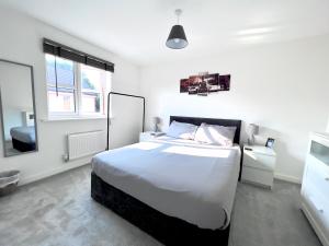 a white bedroom with a large bed and two windows at North Colchester Homestay in Mile End