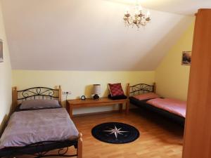een slaapkamer met 2 bedden en een kroonluchter bij Little Poet's Lodge in Schwenningen