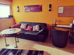 ein Wohnzimmer mit einem Sofa und einem Tisch in der Unterkunft Little Poet's Lodge in Schwenningen