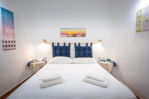 una camera da letto con un grande letto bianco con due cuscini di Favolosa Casa Vacanza a Cefalù a Cefalù