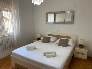 um quarto com uma grande cama branca e 2 almofadas em apartments Marina,Bikić em Marina