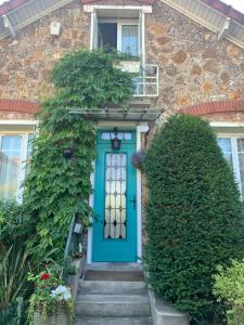 una porta blu su una casa di mattoni con scale di Chambre cosy à Houilles a Houilles