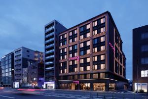 a building on a city street with buildings at Moxy Kyoto in Kyoto