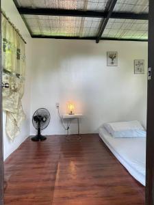 Zimmer mit einem Bett und einem Tisch mit einer Lampe in der Unterkunft The Twin Studio Cottages 