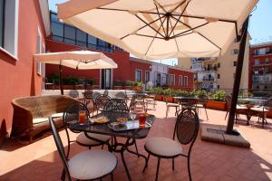a table and chairs with an umbrella on a patio at Hotel Nuvò in Naples