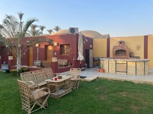 a patio with chairs and a table and a fireplace at Helios Arabians in Cairo