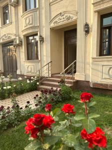 una casa con flores rojas delante de ella en Eurolux Boutique-Hotel en Tashkent