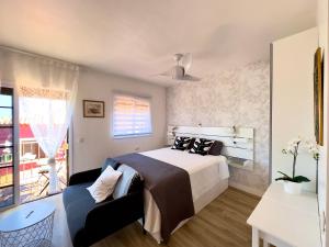 1 dormitorio con cama, sofá y ventana en Las Vistas-Rincón acogedor con vistas al mar en Tabaiba