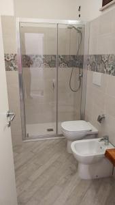 a bathroom with a shower and a toilet and a sink at Minissale Farmhouse in Calatabiano