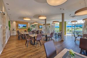 Bachhof Resort Apartments في Kirchroth: غرفة طعام مع طاولات وكراسي ونوافذ
