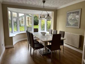 a dining room with a glass table and chairs at Partridge House • Sleeps 9 in Oakham